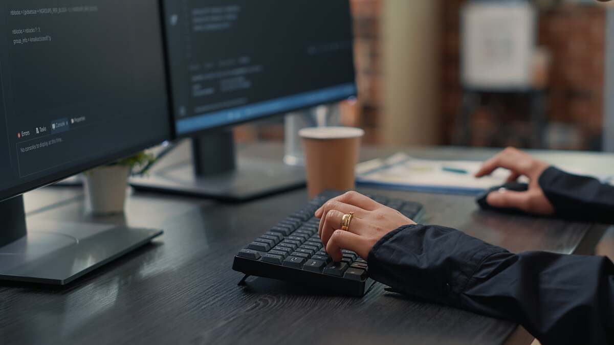 A person sitting at a desk in front of a computer at work